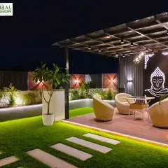 The main pergola seating area in the Sushant Lok project, featuring a backlit Buddha art piece and modern wicker furniture.