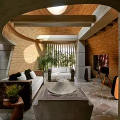 The interior of my studio, where curved walls finished with natural materials and a central oculus create a serene, light-filled environment. This space is designed to foster creativity and demonstrate how raw materials can be used to achieve a sense of sophisticated calm.