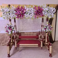 This beautifully decorated wooden swing (jhoola) is a popular rental for Mehendi, Sangeet, or baby shower events. It comes adorned with rich floral arrangements for a perfect photo spot.