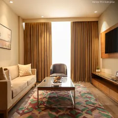 The living area in our deluxe suite provides a generous space to relax. It features a comfortable sofa, armchair, and coffee table, perfect for unwinding after a long day.