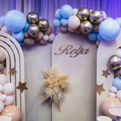 A close-up of our boho-themed decor, showing the custom name 'Reyja' on an arched panel. The design incorporates pampas grass and a soft color palette of muted blues, beiges, and metallic golds.