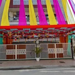 A straight-on view of the decorated entrance gate and canopy. The ceiling is adorned with hanging decorative umbrellas, adding a traditional touch to the modern structure.