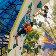 Here you can see two climbers on the wall at once. One is in a life vest for the Psico Jam, while the other competes without one, showcasing the different ways to participate.
