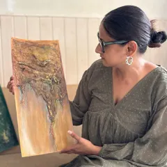 Admiring a piece with a beautiful, flowing texture that resembles a topographical map or a flowing river of sand. The earthy tones are very calming.