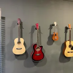 Our wall of guitars, featuring a variety of acoustic guitars and a ukulele. These instruments are available for use during your sessions, so you can just come and start playing.