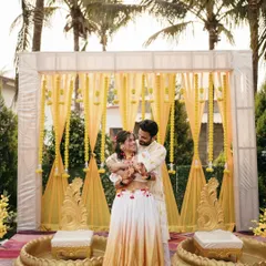 A beautiful portrait of the couple at their Haldi ceremony. The vibrant yellow decor and their coordinated outfits create a picture-perfect moment.