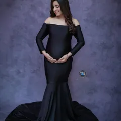 A solo maternity portrait can be incredibly powerful. Here, we used a classic off the shoulder black mermaid gown to create an elegant silhouette, highlighting the beautiful shape of her baby bump against a textured studio backdrop.