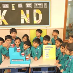 A student takes the lead and pours water into the filtration model, learning about the process of cleaning water through direct, hands-on participation.
