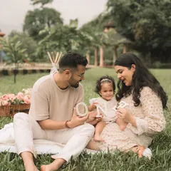 A candid moment during an outdoor family session, spelling out "ONE" for their daughter's first birthday.