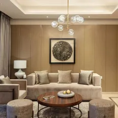 This living room at the Elevate residences features a sophisticated palette of beige and brown, with a modern bubble chandelier and curated art. The space is designed for quiet elegance and comfort.
