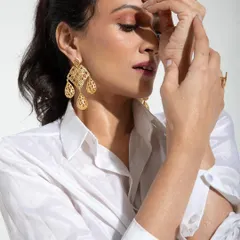 A close-up from the Samoh India shoot, focusing on the delicate interplay of light, shadow, and emotion. The model's pose highlights the intricate gold earrings, making this both a beautiful portrait and an effective accessory shot.