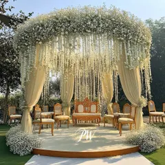 A dream in white. This stunning mandap at the JW Marriott Golfshire features a canopy of baby's breath and cascading white florals, creating a heavenly and elegant atmosphere for an outdoor wedding ceremony.