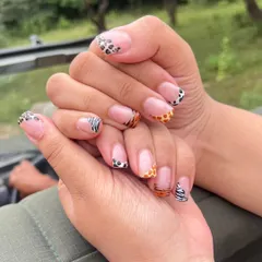 This set shows my skill with detailed, custom nail art, featuring different animal prints like leopard, giraffe, and zebra on each nail in a creative French tip style.