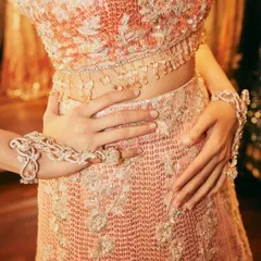 A close-up on the details of the pink sequined Manish Malhotra lehenga, showing the incredible craftsmanship and hand jewelry that completed this iconic look.