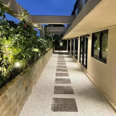 Another evening view of the corporate terrace, this time looking down the length of the walkway. The strategic placement of uplights creates a dramatic and inviting effect, making the terrace a usable and beautiful space long after the sun goes down.