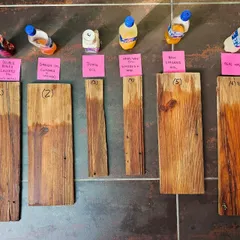 Testing different wood finishes is a crucial part of the restoration process. These samples show various oils and waxes being tested on reclaimed wood, a detail from our hands-on work at The Verdun House.