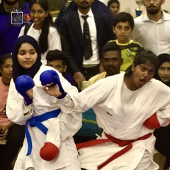The fire of competition. Two female fighters from opposing teams clash during a tournament, showcasing the power and spirit of women in sports karate.