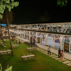 An expansive outdoor reception venue, beautifully lit for an evening of celebration. The combination of open lawn space for mingling and a covered, well-lit structure for dining and dancing shows our expertise in full-venue design.