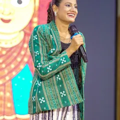 Addressing the audience at an Utkal Divas event. I often share stories about my heritage and the meaning behind the folk dance styles I perform.
