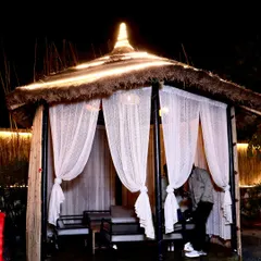One of my larger private cabanas at night. Draped with sheer curtains and lit from above, it provides an elegant and secluded space for a group dinner or celebration.