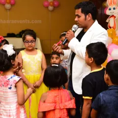 Gathering the children for a fun activity at a party. I make sure to interact with all the young guests to keep them entertained throughout the event.