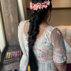 A gorgeous, thick fishtail braid adorned with a crown of pink flowers. This hairstyle is perfect for a Mehendi or Sangeet ceremony.