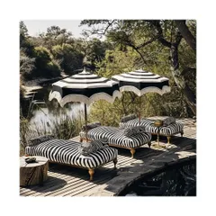 We extend our design philosophy to outdoor sanctuaries, creating spaces that are an extension of your home's interiors. This safari-themed deck uses classic black and white striped, weather-resistant fabrics to create a chic, durable, and relaxing retreat.