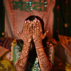 My Mehendi bride showing off her beautiful henna. The focus is on the intricate design that covers her hands and arms.