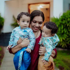 Capturing the bond between a mother and her children is a privilege. This outdoor portrait shows a mother holding her twin boys, dressed in traditional attire, creating a warm and authentic family moment.
