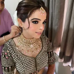 A gorgeous client getting ready for the wedding day. This look features a classic black smokey eye and flawless skin, paired with a traditional floral bun. It’s a timeless choice for any wedding guest.