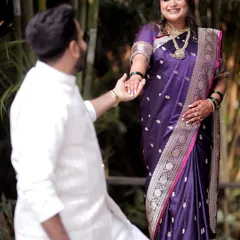 A classic and romantic pose where the groom holds his bride's hand. This image highlights the traditional Maharashtrian attire and the gentle connection between the couple.