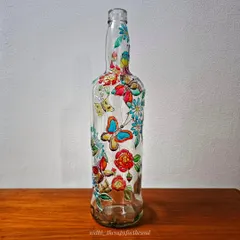 The butterfly bottle on a wooden surface, showing how it can be a beautiful decorative piece for a shelf or table.