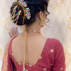 This is an elegant bridal bun decorated with a stunning multi-coloured and pearl hair accessory. This style is perfect for keeping hair neatly off the face while still looking glamorous.