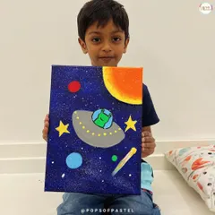 A young boy proudly holds up his out-of-this-world space-themed acrylic painting, created with guidance from our amazing teacher.