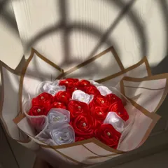 A full view of the classic red and white satin rose bouquet. The elegant wrapping and timeless color combination make it a sophisticated and romantic gift.