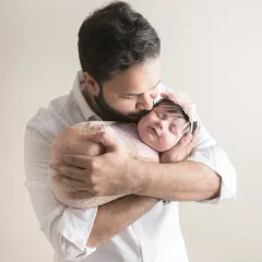 A father's gentle kiss for his newborn daughter. This portrait captures the overwhelming tenderness and protection in that single, quiet moment.