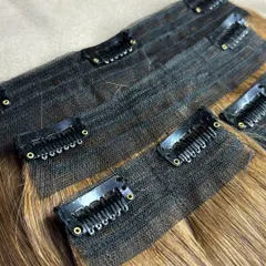 A close-up of the construction of my premium clip-on sets. The clips are designed to be secure yet gentle on your natural hair, with a durable weft that prevents shedding.