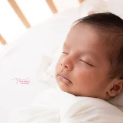 A close-up of a peacefully sleeping baby in their own crib. Lifestyle sessions are all about capturing your baby in their natural environment, creating memories that are truly personal.
