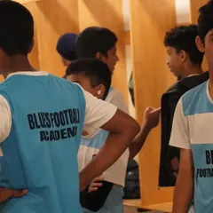 Players in the locker room, listening to instructions and mentally preparing for the match ahead.