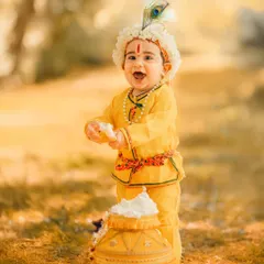 An outdoor Janmashtami shoot with beautiful, soft natural light. This little Krishna enjoys his pot of butter in a lovely park setting, showing our versatility beyond the studio.