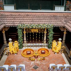Another perspective of the stunning Haldi decor at Angana. The combination of yellow plinths, floral arrangements, and traditional props weaves a tale of festive celebration.
