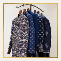 A rack displaying a collection of our intricately embroidered sherwanis in shades of blue. This image represents the magic of vibrant hues and luxurious fabrics that define our brand.