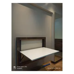Here is the wall-mounted table folded down, creating a sturdy and spacious work surface. This is an excellent space-saving furniture solution for anyone working or studying from home.