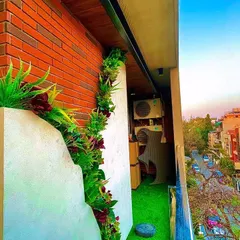 This project in South Delhi shows how we can integrate greenery with existing architecture. We added a vertical garden along a structural element and laid down artificial grass, maximizing the green footprint on this city balcony.