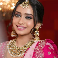 A little sparkle, a soft smile, and a dream painted in pink. This close-up shows the glowing skin and sparkling smokey eyes that define this classic North Indian bridal look.