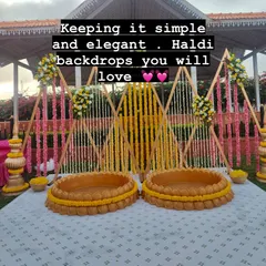Keeping it simple and elegant. This Haldi backdrop with clean lines, floral strings, and traditional 'urli' seating is a design you and your guests will love.