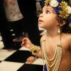 The same child as Kanhaji, looking up with a sense of wonder. This candid shot captures a moment of curiosity during the temple festivities.