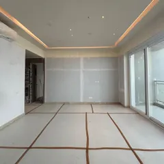 This is the blank canvas stage of a large residential space. The drywall is up and the floor is marked for tiling, showing the clean slate from which we begin to layer in the details, textures, and lighting that will define the final experience.