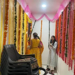 Another view of the housewarming decoration, showing how the flower garlands and pink fabric draping transform a simple hallway into a beautiful ceremonial space.