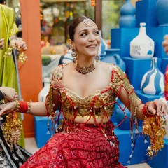 A happy, candid moment from the Mehendi ceremony. The bride's warm, bronzed glow and winged eyes stand out, even in a vibrant, festive setting.